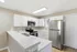 Townhomes at TSC Bright and modern kitchen with sleek stainless steel appliances, elegant white cabinets, and a spacious countertop.