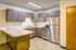 Modern kitchen with sleek wooden cabinetry, stainless steel appliances, and a spacious marble countertop island. Bright and inviting space perfect for culinary adventures.