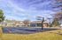 Inviting apartment complex with a vibrant outdoor basketball court, surrounded by lush greenery and bathed in sunlight, perfect for active residents.