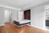 Modern apartment featuring a sleek Murphy bed, hardwood floors, and a crisp, white interior for a spacious feel.