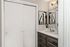Elegant bathroom with modern vanity, large mirror, and artistic decor creating a serene atmosphere.
