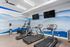 Modern fitness room with sleek treadmills, exercise bike, and vibrant mountain mural for an inspiring workout space.