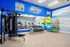 Modern fitness room with vibrant blue walls, mirrors, exercise equipment, and colorful stability balls, perfect for an energetic workout experience.