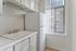 Bright and cozy kitchen with a sleek white sink, modern cabinetry, and large windows allowing natural light to flood in.