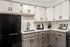 Chic kitchen with modern black appliances, elegant marble countertops, and stylish cabinetry.