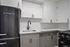 Charming kitchen featuring sleek black appliances, elegant white cabinetry, and modern fixtures for an inviting space.