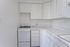 Contemporary kitchen with crisp white cabinets and modern stove, offering ample counter space and a cozy vibe.