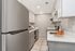 Modern kitchen with sleek stainless steel appliances, bright white cabinetry, and elegant marble countertops.