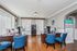 Elegant office space with rich wooden desks, stylish blue chairs, and abundant natural light, featuring modern office equipment and a sign highlighting ongoing multi-million dollar renovations.
