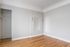 Bright and airy room with elegant hardwood floors, freshly painted neutral walls, and subtle architectural details.