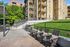 Charming apartment exterior with inviting outdoor seating area, lush green grass, and beautiful architectural details.