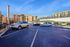 Chic urban apartment complex with convenient parking set against a vibrant, sunny backdrop.