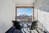 Inviting apartment balcony with two chairs offering a stunning city skyline view, perfect for relaxation and enjoying the sunny day.