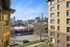 Vibrant urban view showcasing a charming neighborhood street with elegant architecture and a modern city skyline backdrop.