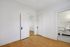 Bright apartment space with elegant hardwood floors, classic white doors, and a bathroom featuring chic black and white tile accents.