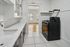 Bright kitchen featuring sleek countertops, modern cabinetry, and a spacious cooking area with open view to an inviting living room.