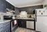 Modern kitchen with sleek dark cabinets, stainless steel appliances, and stylish backsplash, perfect for culinary enthusiasts.