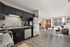 Bright open-concept kitchen and living area with modern appliances, sleek countertops, and large windows for natural light.