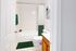 Bright and clean bathroom with classic white tiles, featuring a modern shower curtain, stylish wood cabinet, and elegant decor accents.