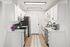 Modern kitchen with sleek white cabinetry, stainless steel appliances, and stylish hardwood floors.