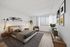 Bright and cozy bedroom with modern decor, featuring a plush bed, elegant wall art, and a serene window view with natural light.