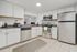 Modern kitchen with sleek stainless steel appliances, granite countertops, and elegant white cabinetry.