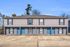 Charming multi-unit townhouse with vibrant blue doors and ample parking, nestled in a serene suburban setting.