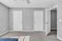 Bright and spacious room with freshly painted gray walls, plush carpet, and double closet doors, offering ample storage.