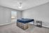 Bright and spacious bedroom with modern bedframe, sleek nightstand, and ceiling fan, offering a cozy and inviting atmosphere.