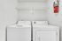 Modern laundry room with top-loading washer, dryer, and convenient overhead shelving.