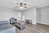 Charming living room with sleek wooden floors, modern seating, and elegant ceiling fan.