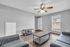 Bright living room with sleek modern furniture, wood flooring, and a ceiling fan, offering a cozy and inviting atmosphere.