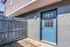 Charming blue entrance door with rustic wood fence, offering a welcoming and secure entryway.
