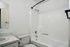 Sleek and modern bathroom with a pristine bathtub, stylish white countertop, and elegant fixtures.