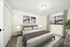 Cozy bedroom featuring a plush bed with stylish bedding, elegant lighting, artistic wall decor, and a scenic window view, offering a serene retreat.
