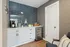 Contemporary kitchen nook featuring a sleek coffee station, modern blue subway tile backsplash, and a stylish mini fridge.