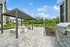 Charming outdoor BBQ area with a modern pergola, stylish seating, and lush garden views, perfect for entertaining.