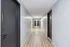 Bright and inviting apartment hallway with sleek modern flooring and elegant door finishes.