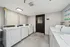 Modern laundry room with sleek white washers and dryers, complemented by clean, minimalist decor.