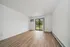 Bright living room with elegant wooden floors, large windows leading to a scenic outdoor view, and a modern air conditioning unit.
