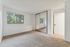 Spacious and bright bedroom featuring plush carpeting, large mirrored closet doors, and a scenic window view, designed for comfort and style.
