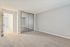 Bright and spacious bedroom with plush carpet, mirrored closet doors, and soft neutral walls, offering a blank canvas for your personal touch.