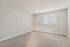 Bright, airy room with soft carpeting, neutral walls, and a large window inviting natural light.