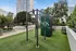 Vibrant outdoor fitness area featuring modern exercise equipment, lush greenery, and elegant urban surroundings.