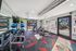 Modern fitness center with vibrant geometric carpet, equipped with weights, exercise balls, and fitness machines, offering a bright and motivational workout space.