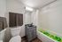 Modern bathroom featuring sleek gray vanity, elegant lighting, and playful green and yellow balls in the bathtub for a unique touch.