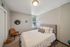 Charming bedroom with cozy decor, featuring a comfortable bed, stylish wall art, and natural light streaming through a window.
