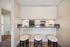 Inviting kitchen with sleek countertops and cozy bar seating for three, perfect for entertaining and casual dining.