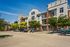 Charming three-story apartment complex with modern brick and siding exterior, featuring private balconies and surrounded by lush greenery.