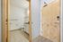 Inviting entrance with a sleek wooden door, leading into a modern bathroom with elegant fixtures and tiled flooring.